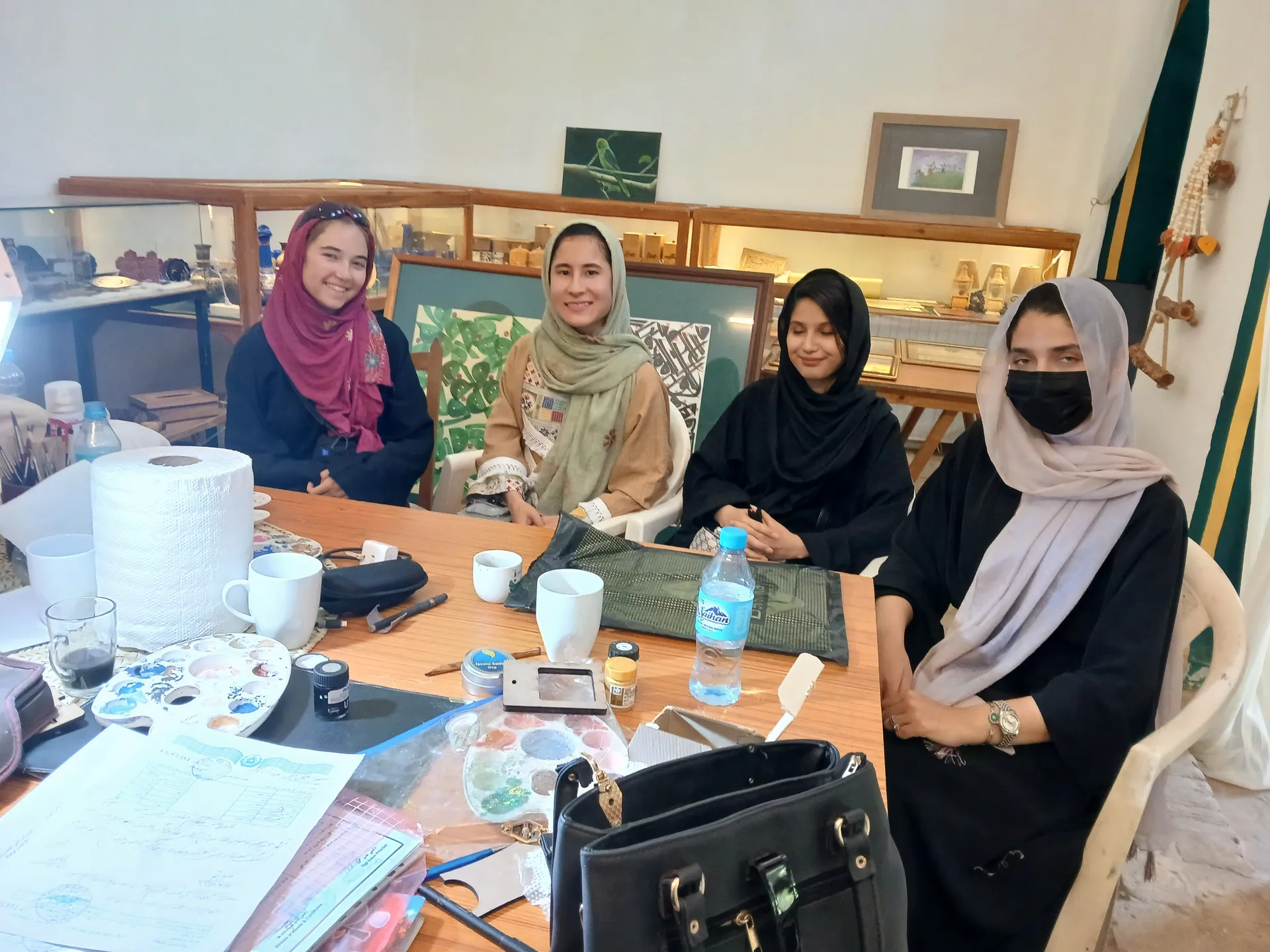 A beautiful meeting of cultures — our female guide, a Swiss traveler, and talented women artists together at a local gallery in Herat