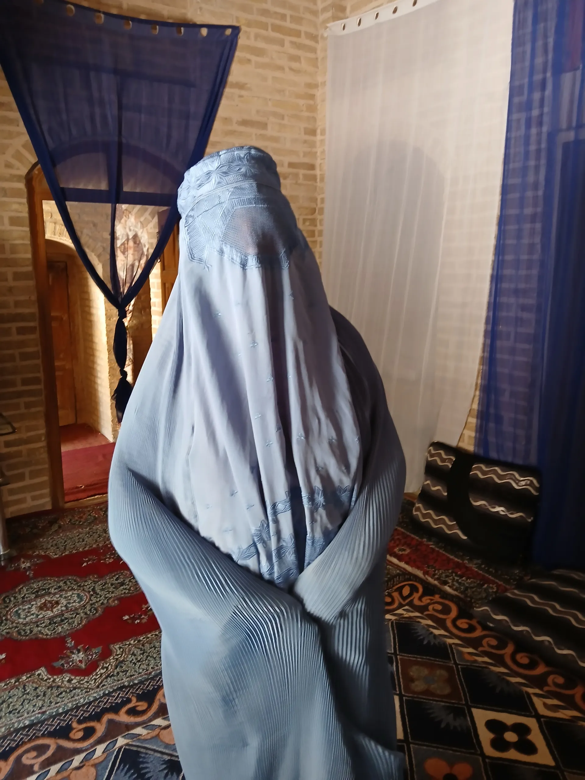 A glimpse into everyday life in Herat, trying on a traditional burqa during a warm visit inside a local family home.